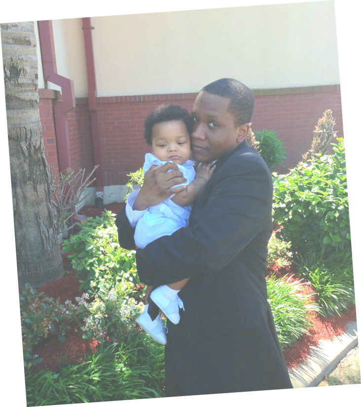 Samuel Celestin as a young adult holding a small child